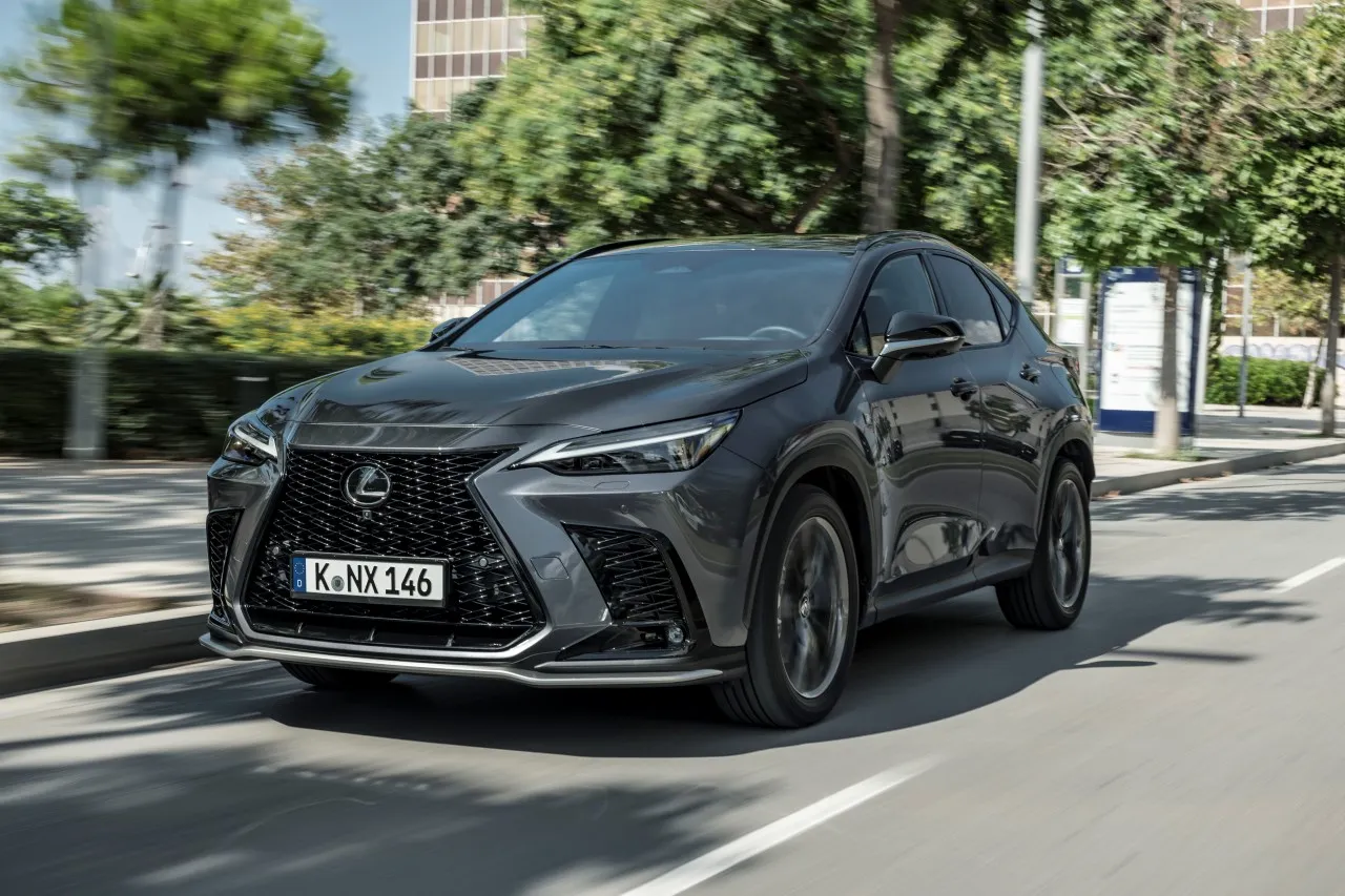 Tmavý Lexus NX v jízdě po městské ulici